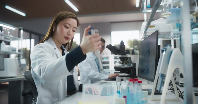 Medical Research Laboratory: Portrait of a Beautiful Japanese Female Scientist Using Micro Pipette for Test Analysis. Advanced Scientific Lab for Medicine, Biotechnology, Microbiology Development