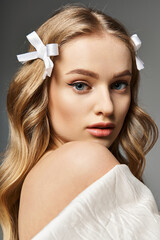 A young, blonde woman captivates in a flowing white dress.