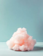 Obraz na płótnie Canvas A fluffy mound of pink cotton candy resembling a cloud, placed off-center on a pale blue background