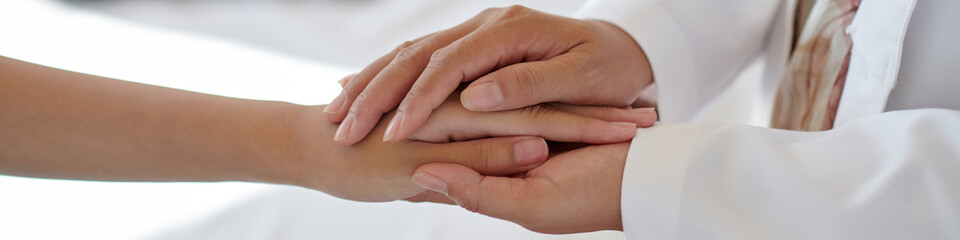 Header with pediatrician touching hands of teenage patient