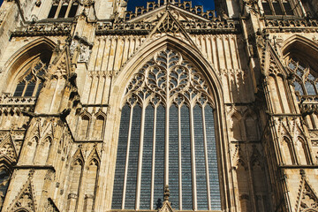 Gothic architecture detail of a cathedral's facade, featuring a large stained glass window and...
