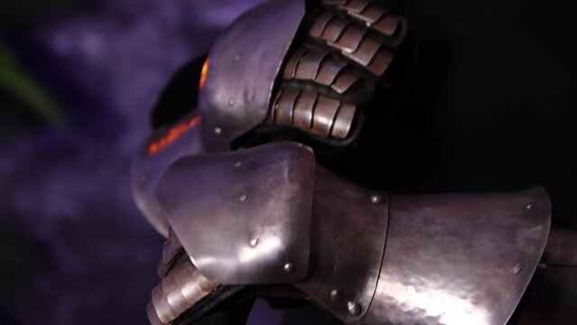 Camera movement, selective focus. Portrait of a young woman with scars on her face, dressed in black clothes, with steel knightly hands and a gorget, holding a bastard sword. Fantasy warrior girl.