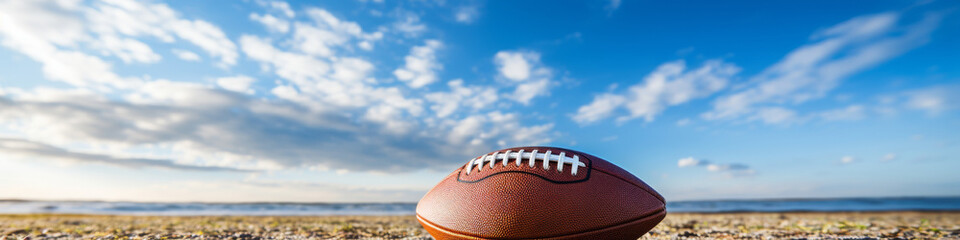 Football on Sandy Beach Against Blue Sky Background