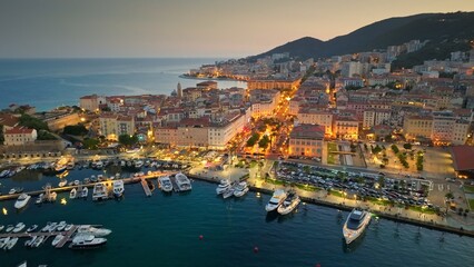 Aerial evening shot of Ajaccio old town, Corsica island. Flying over harbor, old houses and city lights in Ajaccio - capital of Corsica, France - 780553779