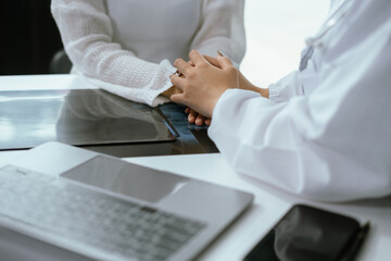 Friendly female doctor hands holding patient hand sitting at the desk for encouragement, empathy,...