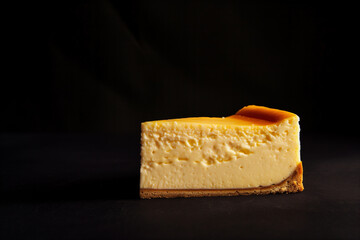 piece of cheesecake on a black background