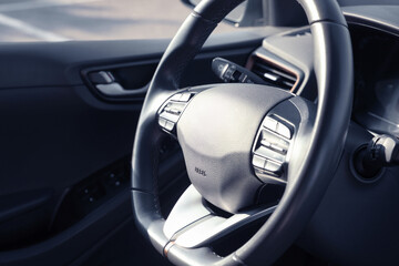 Black steering wheel inside of modern car, closeup. Space for text