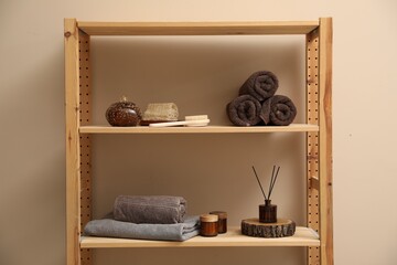 Soft towels, candles, air freshener and spa products on shelves indoors