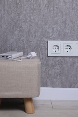 Electric power sockets on grey wall indoors