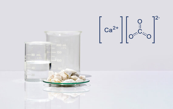 Calcium carbonate chip in chemical watch glass with molecular structure on white laboratory table. Side view