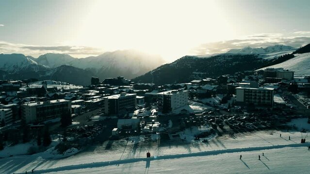 Aerial view of Alpine skiing slope and hotels in famous Alpe d'Huez ski resort, France. High season