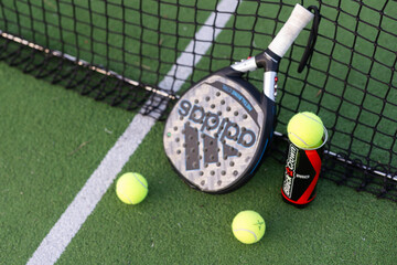 Naklejka premium Ukraine Kyiv, 30.03.2024: Padel racket adidas and padel ball on a green court
