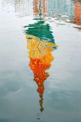 Reflection of something coloured in the water. The colours from green to red are organised vertically and blend into each other, giving the impression of a rainbow. They are irregularly shaped and - obrazy, fototapety, plakaty