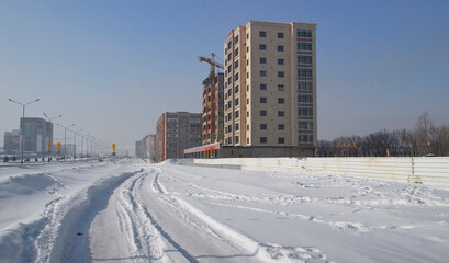 Modern apartment buildings and building under construction. New residential area. Cityscape. Urbanization. Cold Winter. Ust-Kamenogorsk (kazakhstan)