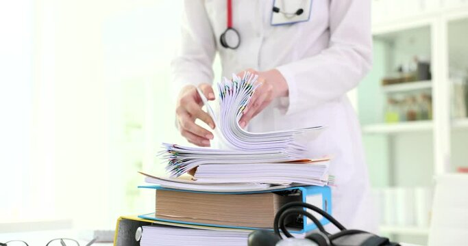 Doctor searching and studying many clinic paper documents closeup 4k movie slow motion. Paperwork in medicine concept 