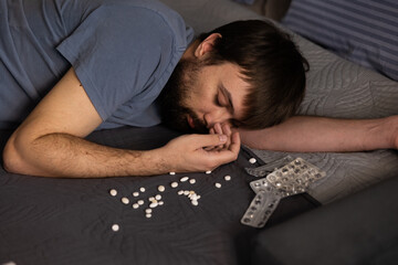 Man lying bed from overdose antidepressants and somnifacient. Psychological and mental problems,...