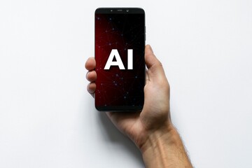 Une personne tient dans sa main droite un téléphone portable sur lequel est inscrit la mention intelligence artificielle - obrazy, fototapety, plakaty