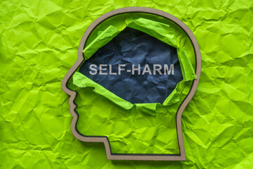 Self-harm concept. Outline of a head and torn paper. - obrazy, fototapety, plakaty