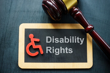 Tablet disability rights and gavel on a dark surface. - obrazy, fototapety, plakaty