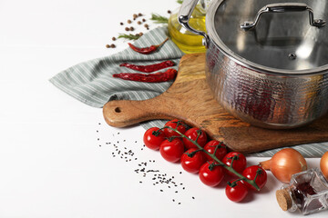 Cooking dinner. Pot, cutting board and different products on white table, space for text