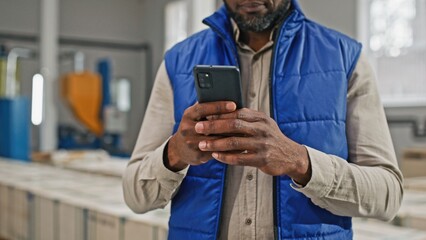 African-American male using his advanced brand-new modernistic modish smartphone with four amazing awesome excellent outstanding cameras. Man typing on his great screen.