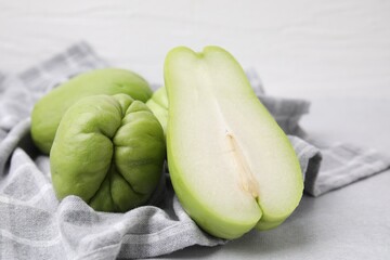 Cut and whole chayote on gray table, closeup