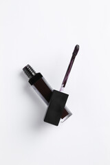Purple lip gloss and applicator on white background, top view