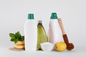 Bottles of cleaning product, brush, sponges and lemon isolated on white
