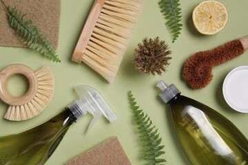 Flat lay composition with different cleaning supplies on green background