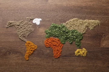 Tuinposter World map of different spices on wooden table, flat lay © New Africa