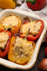 Delicious stuffed peppers in baking dish on table, closeup