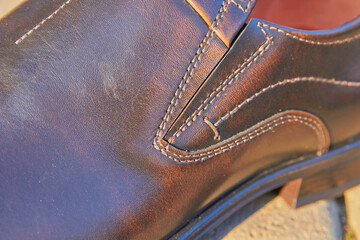 close-up of stitched leather shoes, brown men's shoes with stitched thread, shoes tailoring design