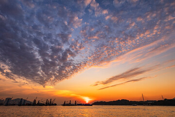 Majestic Sunset Over Busy Industrial Harbor Captured on a Serene Evening