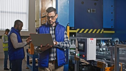 Close-up portrait of serious concerned hard-working Caucasian middle-aged male at workplace. Thoughtful handsome attractive man looks in his tablet and tap the electrician panel screen.