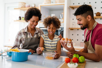 Happy african american family preparing healthy food in kitchen, having fun together on weekend - 780623139