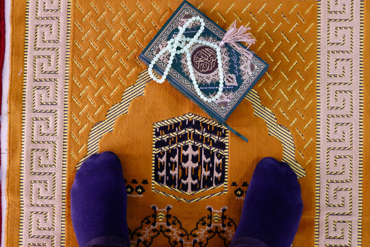Muslim man praying on Islamic prayer mat with the Kaaba, Symbol of Islam, Chau Doc, Vietnam, Indochina, Southeast Asia