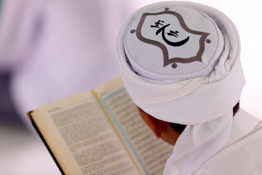 Muslim man reading an Arabic Holy Quran (Koran), Jamiul Azhar mosque, Vietnam, Indochina, Southeast Asia
