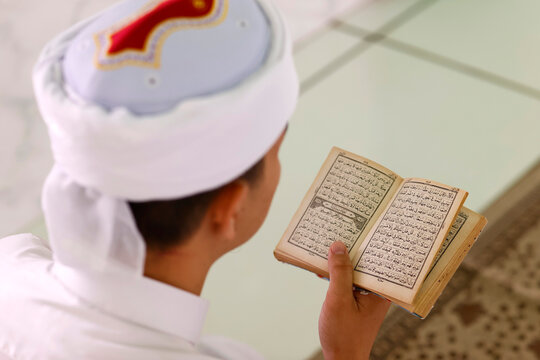 Muslim man reading an Arabic Holy Quran (Koran), Jamiul Azhar Mosque, Vietnam, Indochina, Southeast Asia