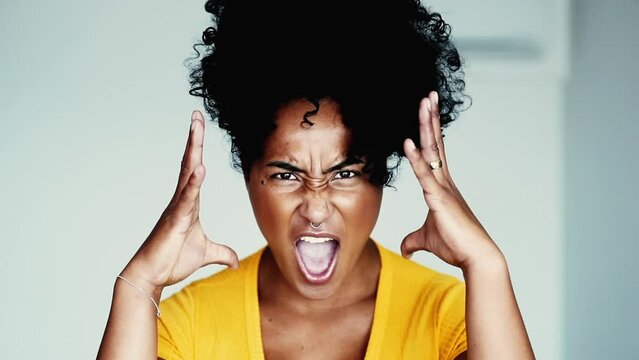 Oen upset young black woman screaming at camera gesticulating with hands and grimacing face feeling extreme anger and frustration. Outraged emovtion of 20s person
