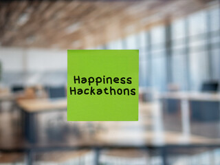 Post note on glass with 'Happiness Hackathons'.