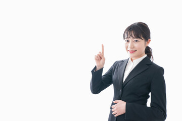スーツ姿で指をさす若い女性