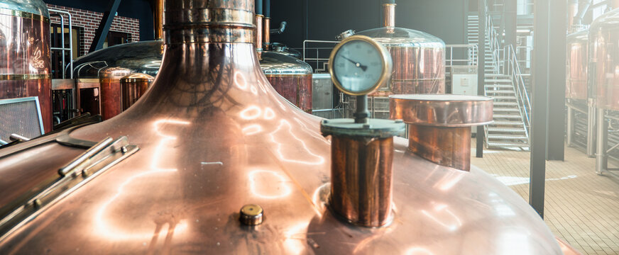 Copper brewery equipment in modern craft beer facility. - Powered by Adobe