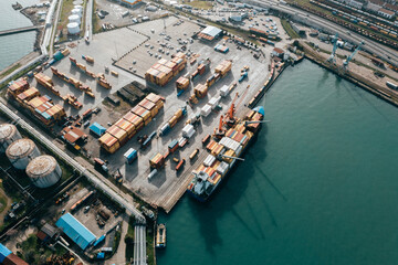 Aerial view of industrial port with stacked shipping containers, international trade and transportation. 