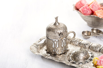 Traditional turkish coffee and turkish delight on white shabby wooden background.