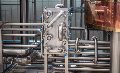 Close-up of stainless steel pipes and valves in a craft brewery.