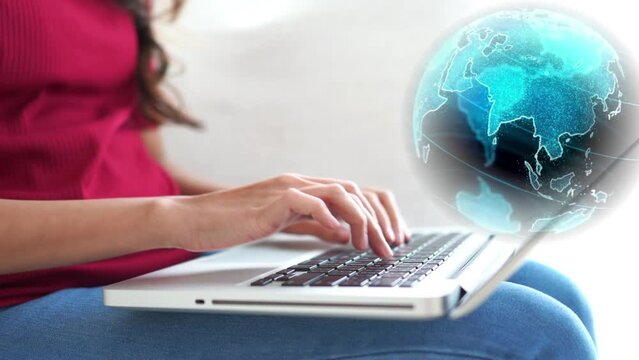 Mujer de negocios escribiendo en su laptop. Se ven sus manos tipeando sobre el teclado. Globo terr&aacute;queo girando encima de su computador. Mujer comunic&aacute;ndose con sus clientes y contactos del mundo.