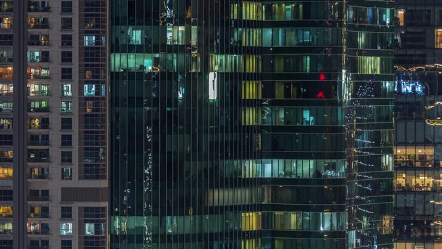 Office and residential buildings windows illuminated at night timelapse. Glass architecture, corporate building at evening with glowing lights