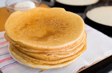 Stack of appetizing flour pancakes in the kitchen during cooking