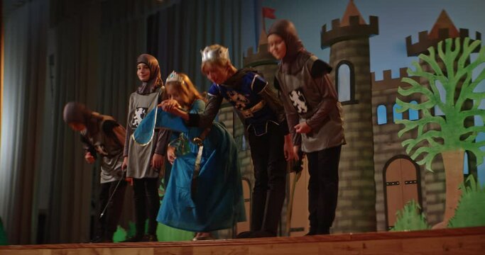 School play depicting medieval times with children in costumes on stage
