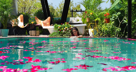 Asian Indian happy young adult gen z woman lady pool enjoy fun joy sunny day hotel trip outdoor...